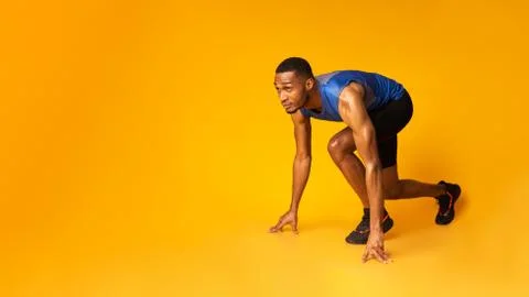 Confident afro guy preparing for a run at studio Stock Photos