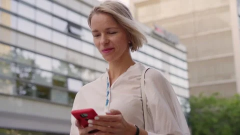 Confident and elegant middle aged blonde Caucasian business woman sends voice Stock Footage 243511534