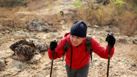 Confident and powerful man with backpack hiking walking on rocky mountains. Stock Footage 171790094