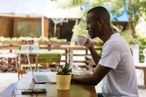 Confident and successful interacial self-employed businessman drinking coffee Stock Photos