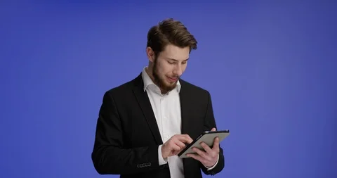 Confident and young man working on his tablet and smiling Stock-Footage 99460138