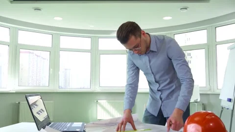 Confident architect engaged in design work at a modern office desk Stock Footage 311992813