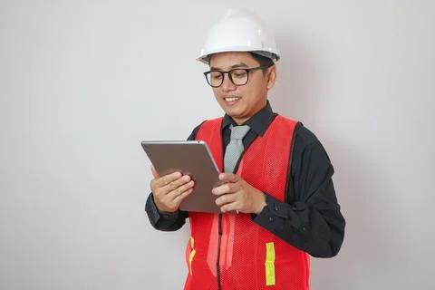 Confident asian engineer man Using tablet for checking and maintenance to i.. Stock Photos