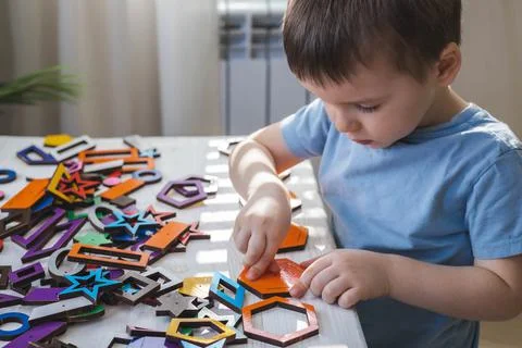 Confident baby boy assembling geometric pattern shape connecting details Stock Photos