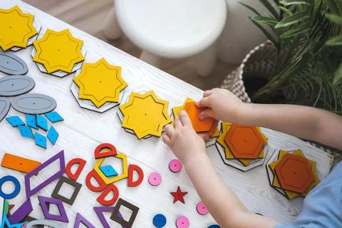 Confident baby boy assembling geometric pattern shape connecting details Stock Photos