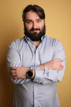 Confident big man with beard, posing over yellow background. Isolated. Photos