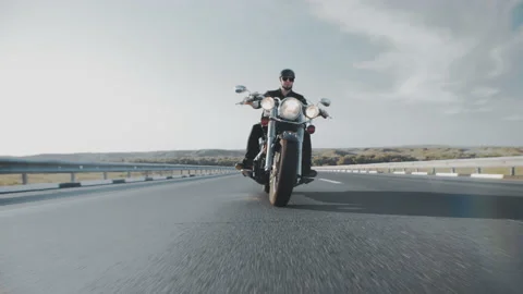 Confident biker in black leather jacket, helmet and glasses rides along the Stock Footage 160092257