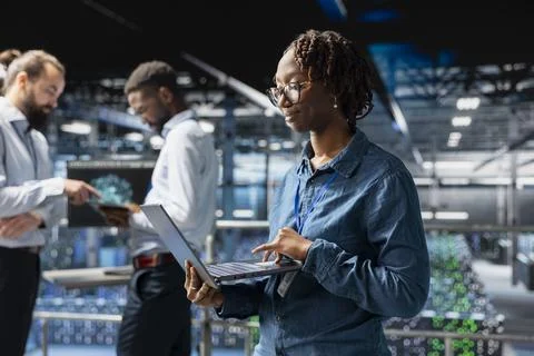 Confident black data scientist in server hub monitoring AI LLM visualization Foto stock