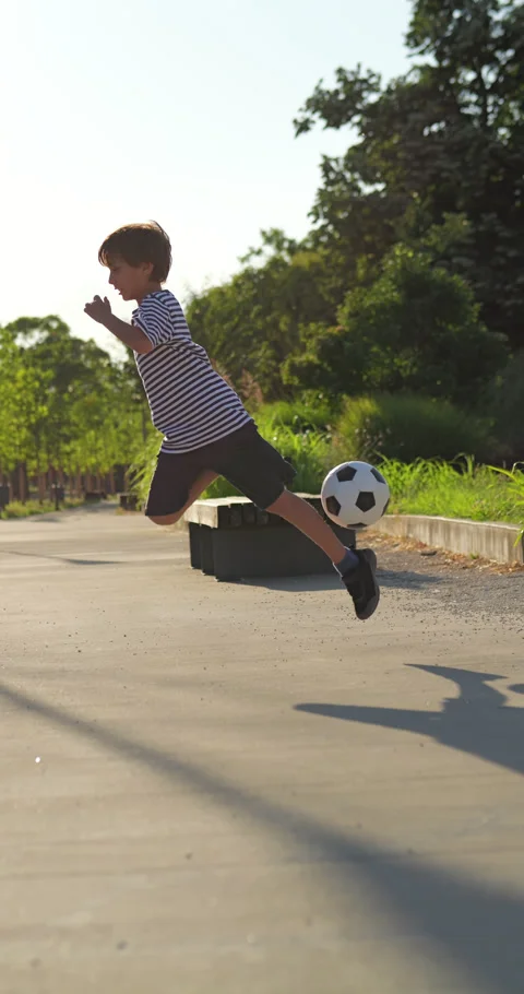 Confident boy performing creative soccer trick variation, slow motion shot 動画素材 344728416