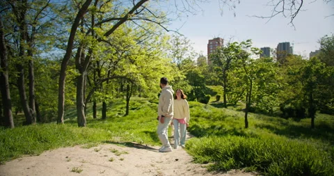A confident brunette guy with a beard in a white hoodie climbs up a hill with Video stock 280614621