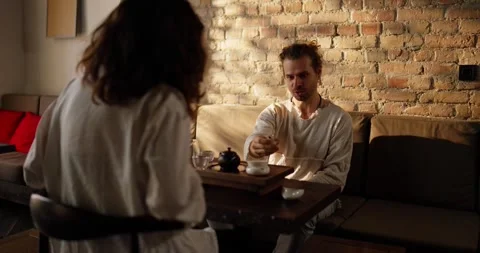 Confident brunette guy talks about accessories for an Asian-style tea ceremony Stock Footage 288470746