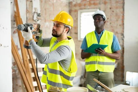 Confident builder posing on indoor construction site Stock Photos