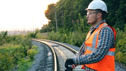 A confident builder stands with crossed hands in a helmet and a vest against the Stock Footage 96590887