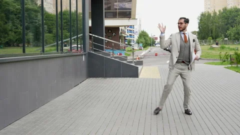 Confident businessman dancing while walking through the city Stock Footage 218313161