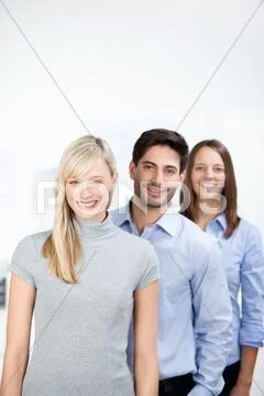 Confident businesspeople standing in row at office Stock Photos