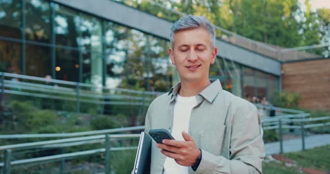 Confident Caucasian man in jacket and tie walking outdoors on a sunny summer day Stock Footage 346755341