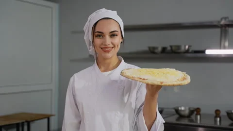 Confident chef presenting a cheese pizza in kitchen Stock Footage 299657427