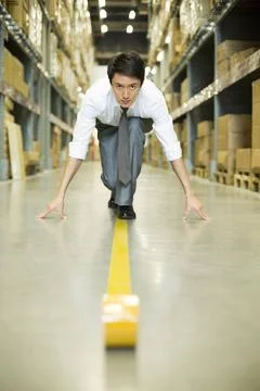  Confident Chinese businessman ready to run in warehouse Beijing China Cop... Stock Photos