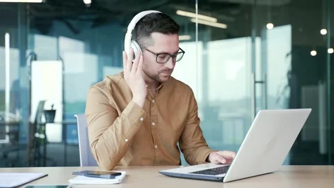 Confident coder IT programmer writes code on a laptop while sitting at a work Video stock 254512323