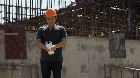Confident construction engineer checking work at construction site. Stock Footage 117330404