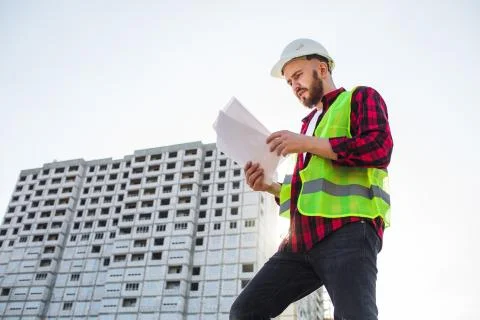 Confident construction engineer in hardhat with using cell phone on construction Foto stock