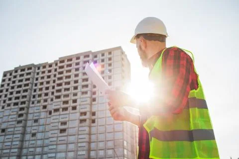 Confident construction engineer in hardhat with using cell phone on construction Foto stock