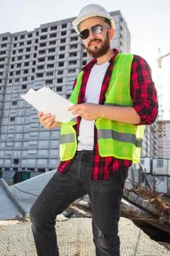 Confident construction engineer in hardhat with using cell phone on construction Stock Photos