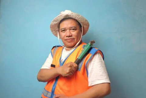 Confident Construction Worker Holding Pipe Wrench Against Blue Wall Stock Photos