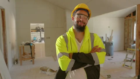 Confident Construction Worker Smiling and Posing Indoors at Job Site, Exuding Stock Footage 305818223