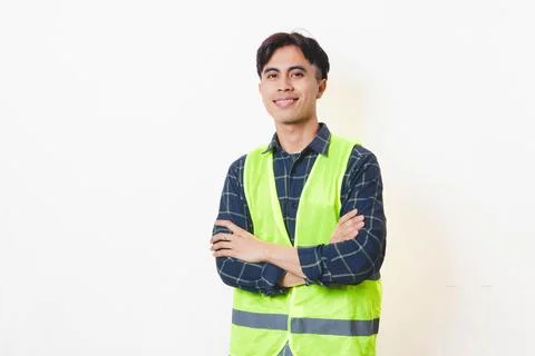 Confident construction worker standing with arms crossed against a clean ba.. Stock Photos