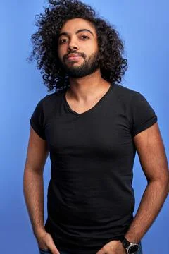 Confident curly arabic guy posing at camera Stock Photos
