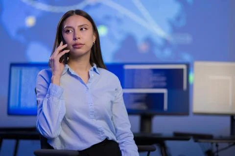 Confident cybersecurity professional analyzing data while communicating in a Stock Photos
