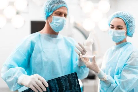 Confident doctors discussing bone model while looking at it Stock Photos