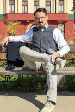 Confident elegant man sitting on the bench with a book Stock Photos