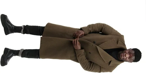 Confident elegant middle-aged black man standing and buttoning his light brown 動画素材 194457574