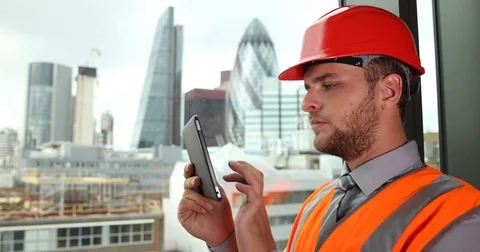 Confident Engineer Man Typing Report on Digital Tablet Looking Out Construction Stock Footage 77005753