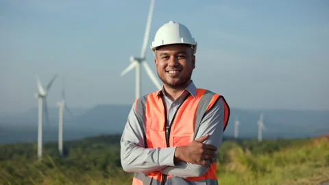 Confident Engineer man with white safety helmet standing front wind turbines. Stock Footage 222888180