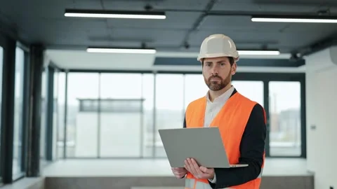Confident Engineer in an Office Building Uses Laptop for Construction Project Stock Footage 307826984