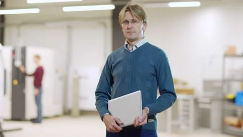 Confident engineer posing with laptop in lab Stock Footage 142160661