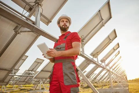 Confident engineer using tablet in solar power farm Stock Photos