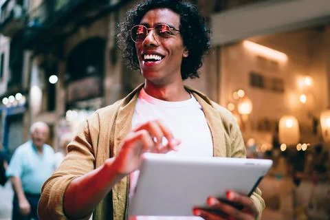 Confident ethnic man using tablet on city street Stock Photos
