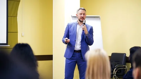 Confident executive manager with microphone speaking at meeting for the public. Stock Footage 107261822