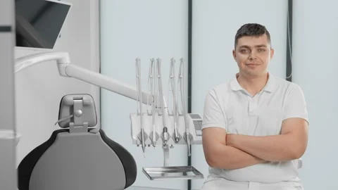 With a confident expression on his face, the dentist sits in front of the camera Stock Footage 274298433