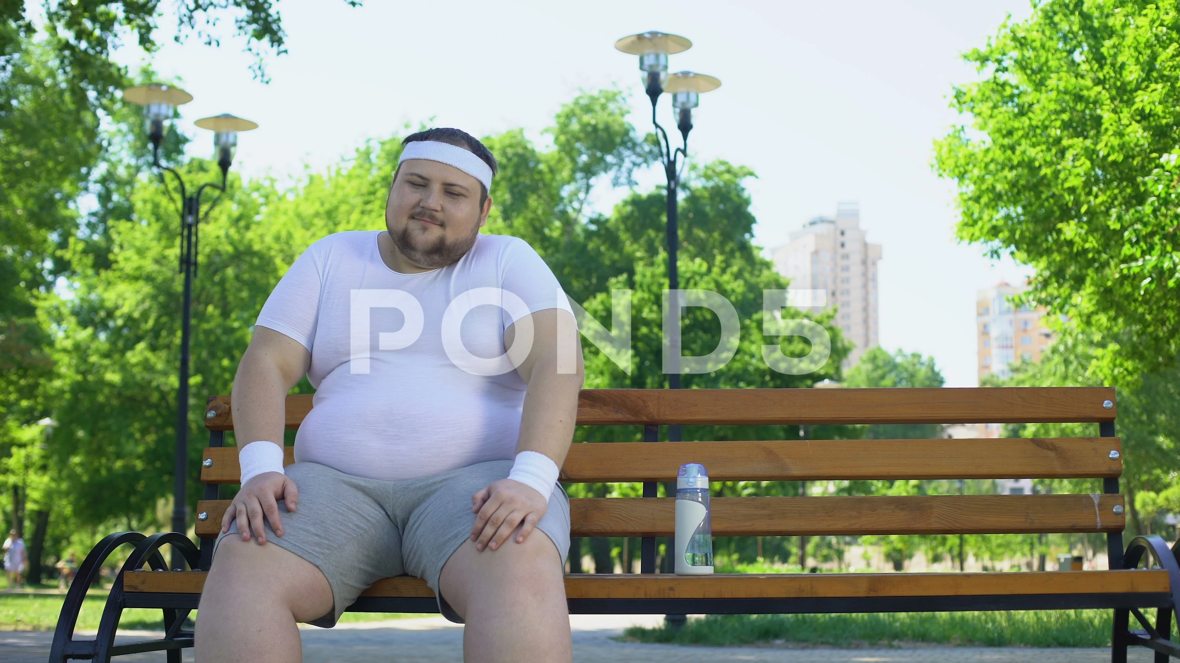 Confident fat man sitting in park, feels happy, contented with life,  self-love