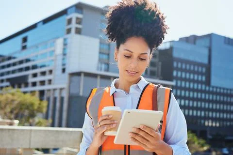 Confident Female Construction Worker Using Tablet on Worksite with Coffee Stock Photos