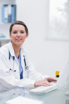 Confident female doctor using computer at clinic 写真素材