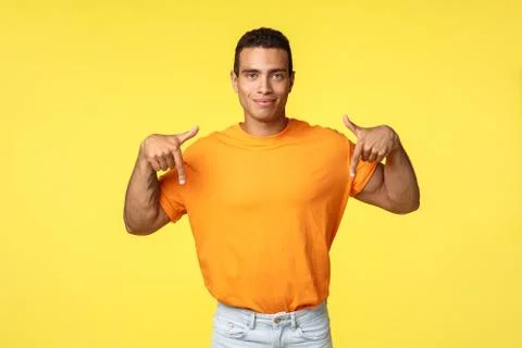Confident good-looking guy with assertive smile, pointing fingers down to Stock Photos