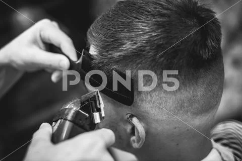 Confident guy sitting at beauty salon . Man haircut. Soft focus. Stock Photos