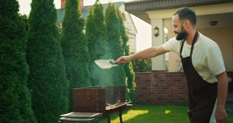 Confident happy brunette guy with a beard in a white T-shirt and a brown apron Stock Footage 280251587