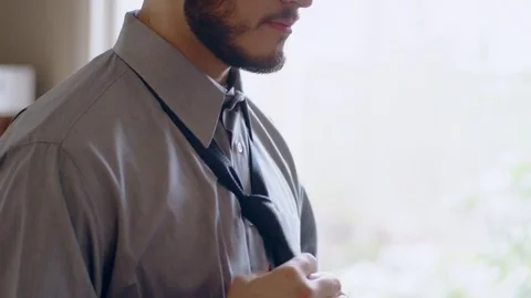 Confident hispanic man tying necktie getting ready in front of mirror Stock Footage 84483400